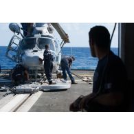 L'équipe de la frégate de surveillance Ventôse préparent un hélicoptère Panther AS-565 sur le pont arrière du bâtiment, en mer des Caraïbes.