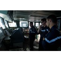 L'équipage de quart consulte la carte maritime en passerelle de la frégate de surveillance Ventôse, en mer des Caraïbes.
