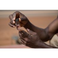 Le caporal-chef Mohamed prélève un échantillon pour contrôler la turbidité et la contentration de chlore de l'eau d'une citerne à Gao, au Mali.