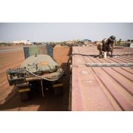 Le caporal-chef Mohamed remplit une citerne d'eau au moyen d'un bac souple chargé sur la plateforme de son camion TRM-10000 à Gao, au Mali.