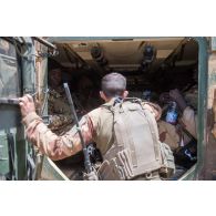 Un chef de bord du 7e bataillon de chasseurs (BCA) donne des instructions à des soldats maliens montés à l'intérieur d'un véhicule de haute mobilité (VHM) dans la région de N'Daki, au Mali.