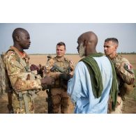 Un chef de groupe malien interroge un habitant aux côtés du capitaine Guillaume, chef du partenariat militaire opérationnel (PMO) dans le secteur de N'Daki, au Mali.