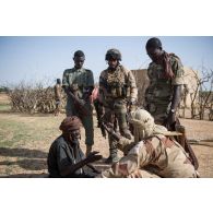 Un prévôt de la gendarmerie malienne interroge un habitant aux côtés de soldats maliens et d'un chasseur du 7e bataillon de chasseurs alpins (BCA) dans le Gourma malien.