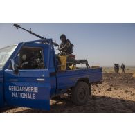 Des gendarmes nigériens sécurisent le périmètre d'une insturction à bord de leur pick-up à Ouallam, au Niger.