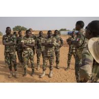 Un instructeur dirige un briefing auprès de gensarmes nigériens pour une formation d'artillerie légère à Ouallam, au Niger.