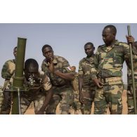 Des gendarmes nigériens mettent un batterie un mortier de 81 mm léger long renforcé (MO-81 LLR) auprès d'un instructeur à Ouallam, au Niger.