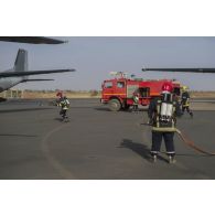 Des pompiers de l'air interviennent sur un avion Transall C-160 au moyen d'un véhicule mousse aéronautique Sides VMA 72 sur la base de Niamey, au Niger.