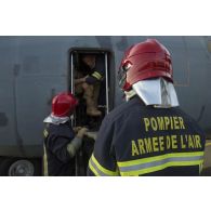 Des pompiers de l'air s'entraînent à évacuer un pilote depuis le cockpit d'un avion Transall C-160 à Niamey, au Niger.
