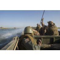 Des soldats du 1er régiment d'infanterie (RI) et des soldats maliens patrouillent sur le fleuve Niger à bord de leur pirogue en direction du village de Kaoïma, au Mali.