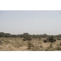 Des commandos parachutistes (GCP) et des soldats nigériens sécurisent le périmètre d'une patrouille à bord de leurs picks-ups Masstech, au Niger.