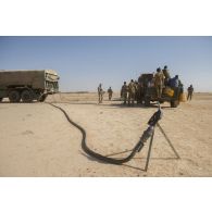 Ravitaillement d'un pick-up malien en carburant par un camion-citerne polyvalent de 10 m3 (CCP10) du Service des essences des armées (SSA) dans le désert malien.