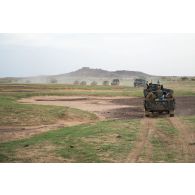 Des soldats maliens ferment la route d'un convoi à bord de leur pick-up dans le Gourma, au Mali.