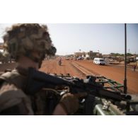 Un tireur d'élite à longue distance (TELD) du 1er régiment de tirailleurs (RTir) assure la sécurité arrière d'un convoi en trappe de son véhicule de l'avant blindé (VAB) dans les rues de Gao, au Mali.