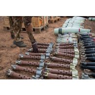 Un pyrotechnicien malien déconditionne des obus de 80 mm pour leur destruction dans un fourneau sur un polygone d'explosions à Gao, au Mali.
