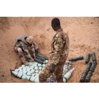 Un pyrotechnicien du détachement des munitions (DETMu) dépose des obus de 120 mm dans un fourneau sur un polygone d'explosion à Gao, au Mali.