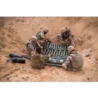 Des pyrotechniciens du détachement des munitions (DETMu) installent des charges coupantes sur des obus de 120 mm dans un fourneau sur un polygone d'explosion à Gao, au Mali.