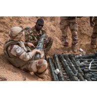 Des pyrotechniciens du détachement des munitions (DETMu) installent des charges coupantes sur des obus de 120 mm dans un fourneau sur un polygone d'explosion à Gao, au Mali.