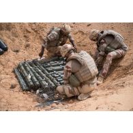 Des pyrotechniciens du détachement des munitions (DETMu) relient des charges coupantes à du cordon détonnant pour la destruction de munitions sur un polygone d'explosion à Gao, au Mali.