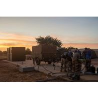 Des soldats du 1er régiment d'infanterie (RI) font leur toilette au moyen d'une remorque douche RD 3000 à Ouallam, au Niger.