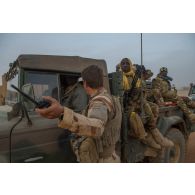 Des soldats maliens s'apprêtent à partir en mission à bord de leur pick-up à Ménaka, au Mali.