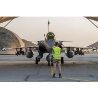 Accompagné par un mécanicien de piste, un pilote Rafale effectue la mise en route de son appareil lors d'une visite pré-vol avant de partir en mission depuis la BAP (base aérienne projetée) en Jordanie.