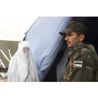 Consultations pour la population civile à l'hôpital jordanien de l'aéroport de Mazar e Charif. Un soldat jordanien, assurant la sécurité à l'entrée de l'hôpital, gère l'affluence et la file d'attente des femmes afghanes voilées venues consulter.