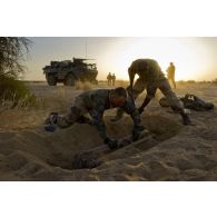 Des sapeurs du 31e régiment du génie (31e RG) exhument des bombes d'aviation enfouies dans le sable en vallée d'Inaïs, au Mali.