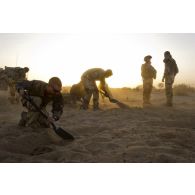Des sapeurs du 31e régiment du génie (31e RG) exhument une cache d'armes enfouie dans le sable en vallée d'Inaïs, au Mali.