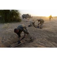 Un sapeur du 31e régiment du génie (31e RG) exhume une bombe d'aviation enfouie dans le sable en vallée d'Inaïs, au Mali.