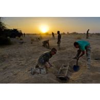 Des sapeurs du 31e régiment du génie (31e RG) exhument une bombe d'aviation enfouie dans le sable en vallée d'Inaïs, au Mali.