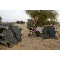 UN sapeur du 31e régiment du génie (31e RG) comptabilise des bombes d'aviation découvertes dans une cache d'armes enfouie dans le sable en vallée d'Inaïs, au Mali.