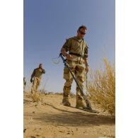 Un sapeur du 31e régiment du génie (31e RG) inspecte une zone au détecteur de métaux en vallée d'Inaïs, au Mali.