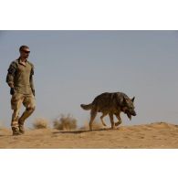 Un maître-chien du 6e régiment du génie (6e RG) inspecte la zone avec son chien Kapa en vallée d'Inaïs, au Mali.
