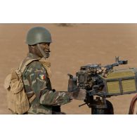 Un soldat malien sert une mitrailleuse lourde à l'arrière d'un pick-up dans la région de Gao, au Mali.