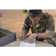 Un prévôt remplit un formulaire avant de plomber une caisse à Gao, au Mali.