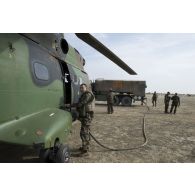 Les soldats du Service des essences des armées (SEA) ravitaillent un hélicoptère Puma SA-330 du 5e régiment d'hélicoptères de combat (5e RHC) en carburant sur la piste de Tombouctou, au Mali.