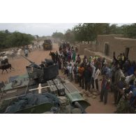 Des habitants saluent au passage des commandos parachutistes de l'air n°20 (CPA 20) à bord de leur véhicule de l'avant blindé (VAB) à Niafounké, au Mali.