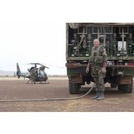 Un soldat du Service des essences des armées (SEA) ravitaille les hélicoptères du 5e régiment d'hélicoptères de combat (5e RHC) en carburant au moyen d'un train routier avitailleur à Goundam, au Mali.