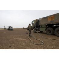 Un soldat du Service des essences des armées (SEA) ravitaille les hélicoptères du 5e régiment d'hélicoptères de combat (5e RHC) en carburant au moyen d'un train routier avitailleur à Goundam, au Mali.