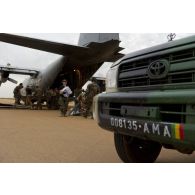 Des soldats déchargent du ravitaillement en eau depuis un avion Super Hercules C-130H de l'armée de l'Air belge sur l'aéroport de Mopti, au Mali.