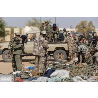 Des soldats maliens disposent de l'armement trouvé dans une cache d'armes pour une présentation à la presse à Gao, au Mali.