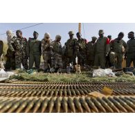 Des soldats maliens disposent de l'armement trouvé dans une cache d'armes pour une présentation à la presse à Gao, au Mali.