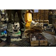 Un soldat malien dispose de l'armement trouvé dans une cache d'armes pour une présentation à la presse à Gao, au Mali.