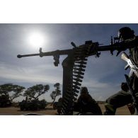 Un soldat malien sert une mitrailleuse Kord de 12,7 mm à l'arrière d'un pick-up à Markala, au Mali.