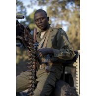 Un tireur malien sert une mitrailleuse Norinco type 77 de 12,7 mm à l'arrière de son pick-up lors d'une patrouille à Niono, au Mali.