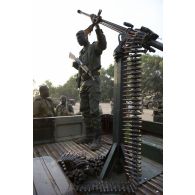 Un tireur malien sert une mitrailleuse Norinco type 77 de 12,7 mm à l'arrière de son pick-up lors d'une patrouille à Niono, au Mali.