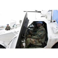 Un caporal de l'armée française présente le poste de conduite d'un VBL (véhicule blindé léger) à un militaire ghanéen lors d'une patrouille.