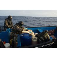 Des commandos de l'équipe de visite de la frégate de surveillance Ventôse tiennent des narcotrafiquants en joue lors de l'interception de leur embarcation en mer des Caraïbes.
