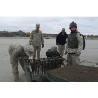 Groupe de démineurs américains manipulant un robot chenillé de neutralisation de mines antipersonnel à Mazar e Charif.