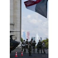 Coulisses : personnels de la circulation routière sous l'Arc de Triomphe observant l'arrivée du défilé aérien des 9 Alphajet de la Patrouille de France lors de la cérémonie du 14 juillet 2011.